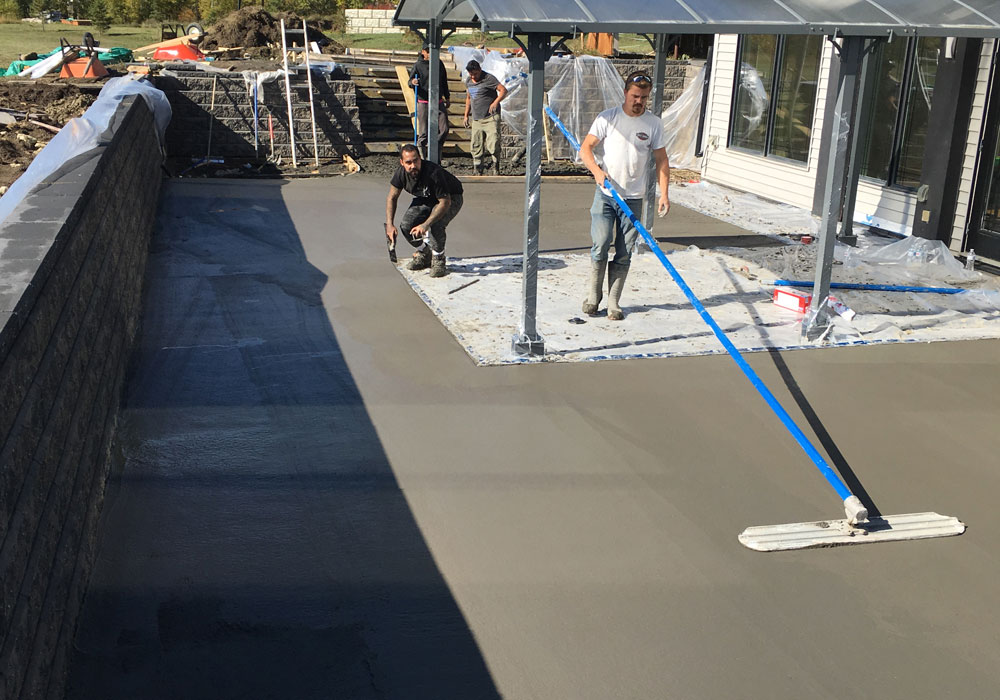 CreativeMan smoothing out the concrete patio before stamping